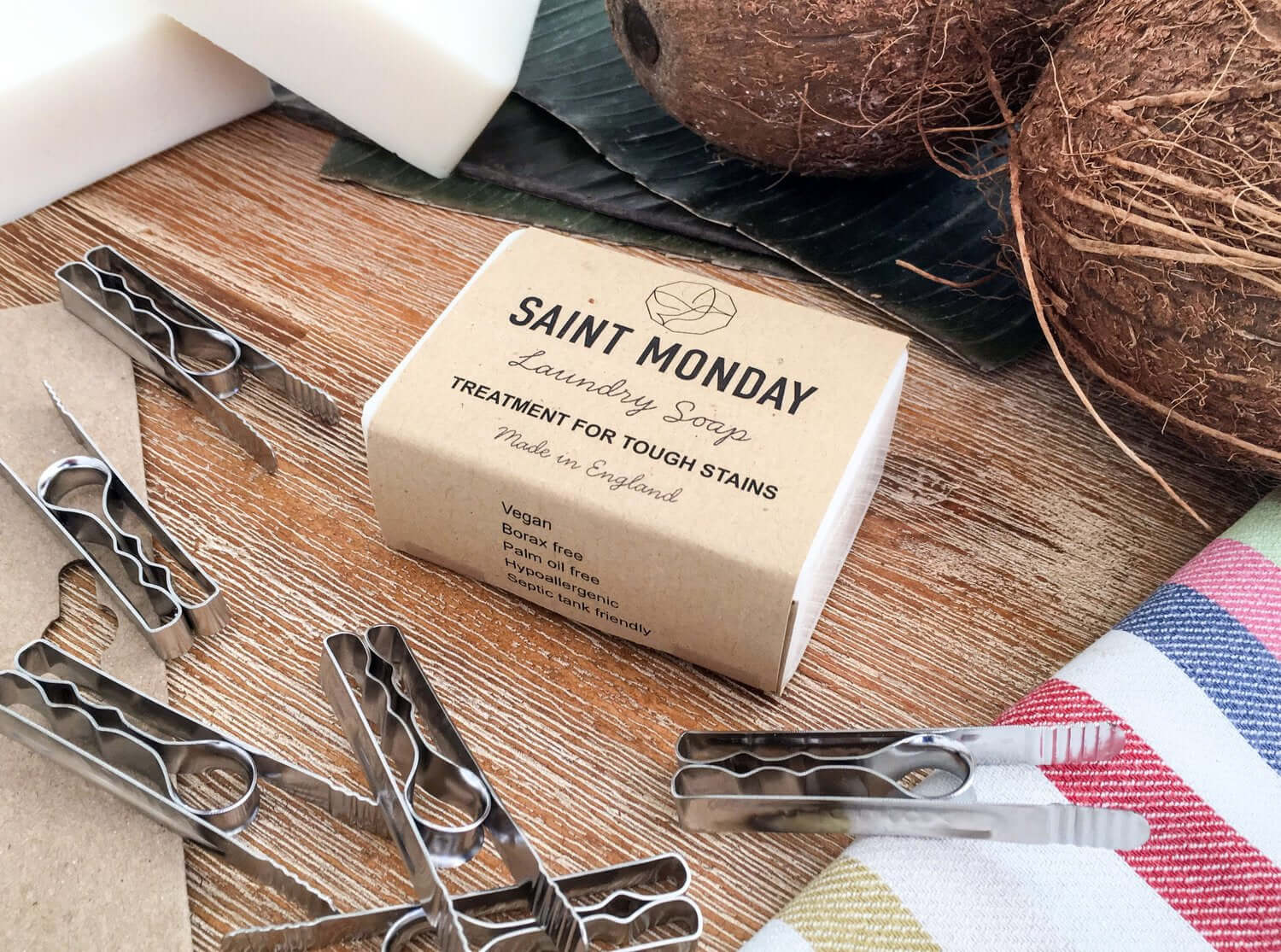 Saint Monday Laundry Soap made from Pure Coconut Oil, vegan, biodegradable, and phosphate-free, displayed with coconuts and clothespins.